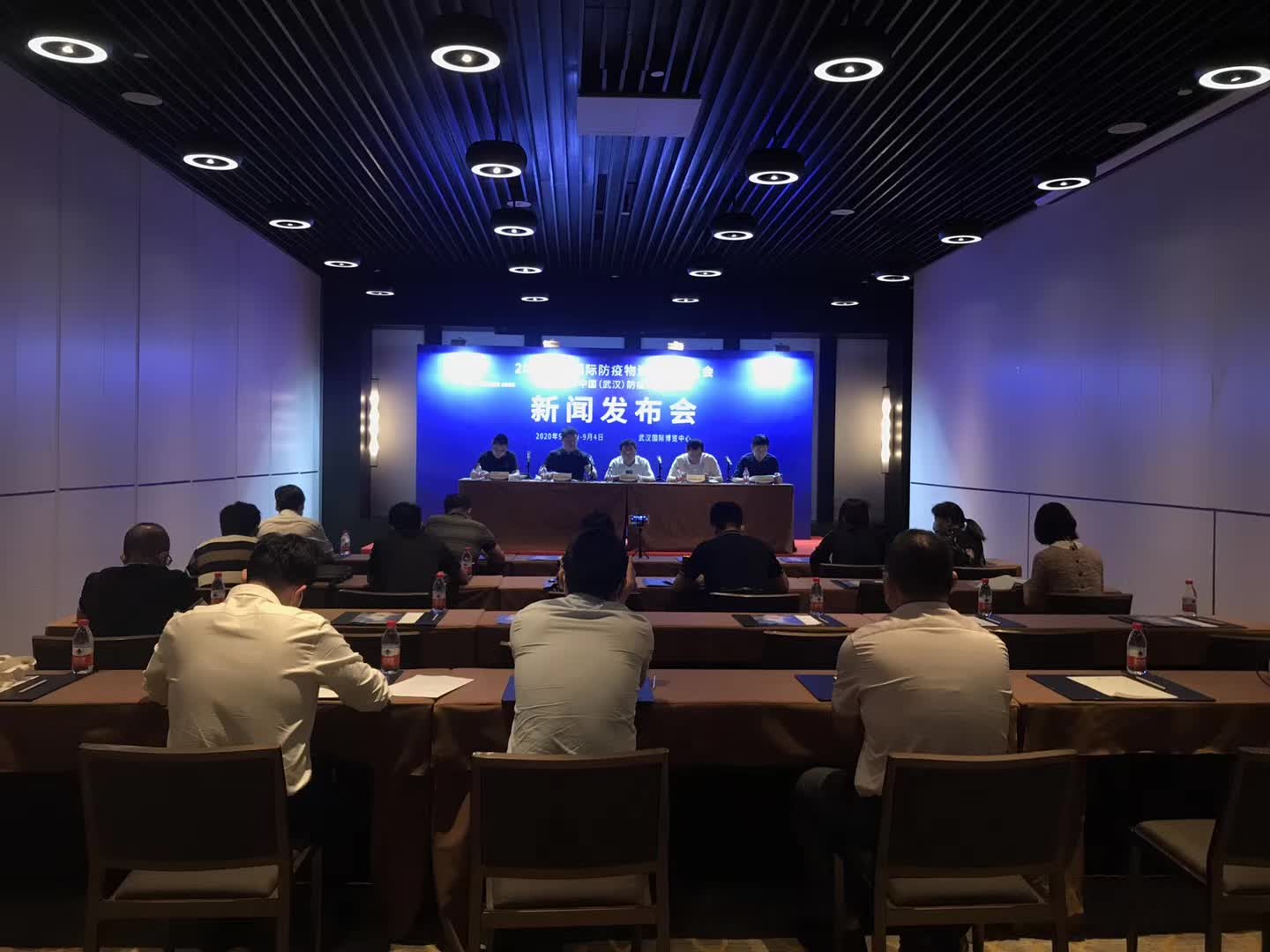 A sparsely attended press conference at Wuhan International Expo Center, September 2020, with attendees masked and socially distanced
